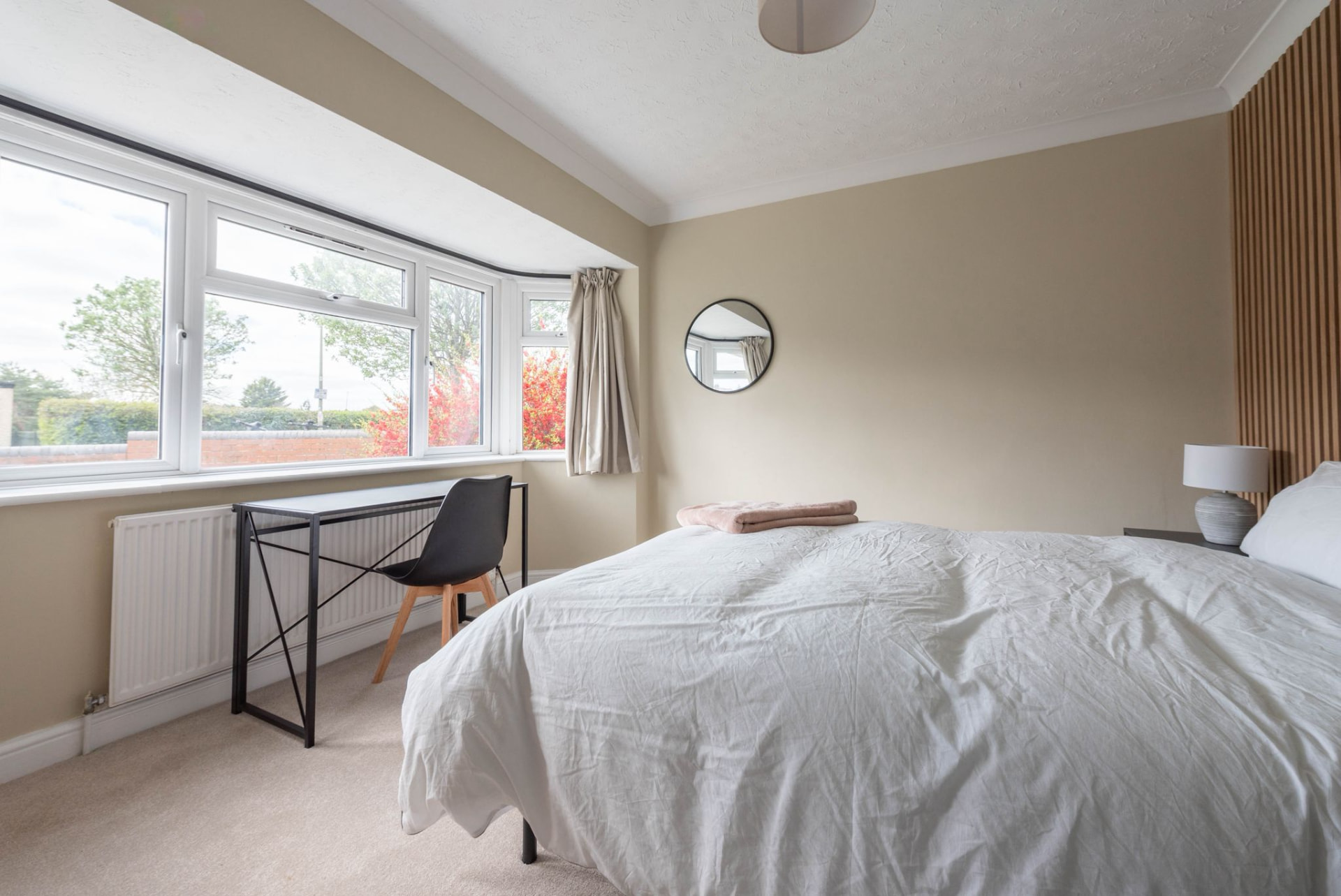 Bright finished bedroom with wooden slat headboard after renovation